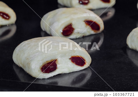 Uncooked mini homemade buns with chocolate filling in electric oven 103367721