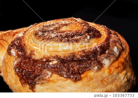 One baked cinnamon bun in electric oven at home, black background 103367733