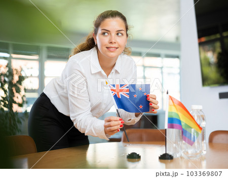Young lady sets miniatures flags of LGBT and Australia before international negotiations 103369807