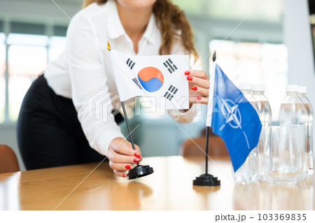Young female secretary preparing room for international negotiations between nato and south korea 103369835