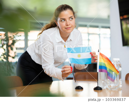 Young lady sets miniatures flags of LGBT and Argentina before international negotiations 103369837