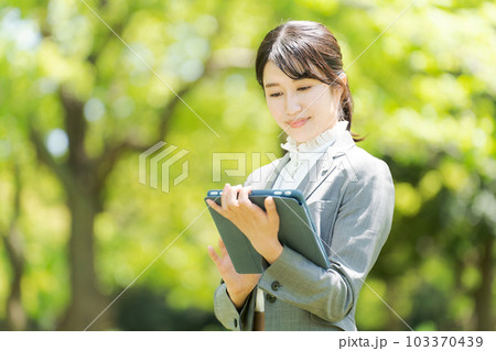 新緑の中に立つ女性の写真 新緑の中に立つ女性の写真 103370439