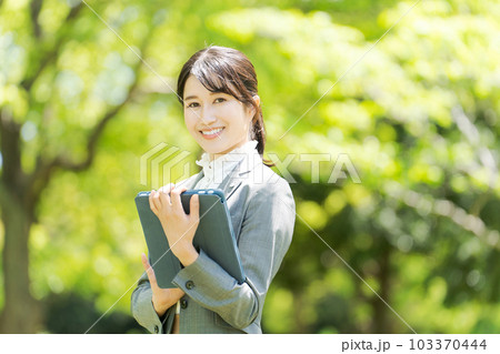 新緑の中に立つ女性の写真 103370444