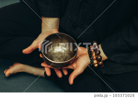 Top view crossed two palms holding a copper singing bowl. Relaxation and meditation. Alternative medicine. Tibetan and Himalayan singing bowls. Make a sound 103371028