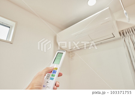 リモコン操作をしている男性　エアコン　空調 103371755
