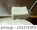 湯気が上がる湯豆腐をすくう-01 103372959