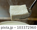 湯気が上がる湯豆腐をすくう-02 103372960