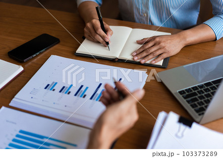 Close up of businessman is explaining business data and new project to partners and writing notes 103373289