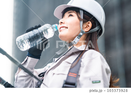 水分補給をする若い女性とび職人 103373928