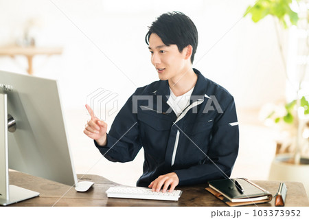 作業着姿でパソコンに向かう若い男性エンジニア 103373952