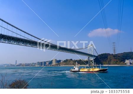 青空の関門橋と関門海峡を走る船 103375558
