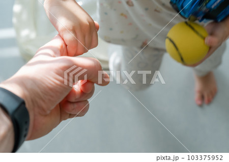 父親の指を握る小さな子供の手 父親の指を握る小さな子供の手 103375952