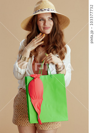 happy elegant woman in blouse and shorts against beige 103377732