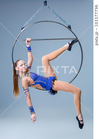 Cute artistic gymnast exercising with hanging hoop Cute artistic gymnast exercising with hanging hoop 103377796