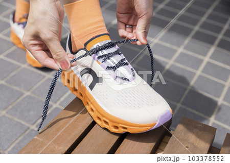 ランニングシューズの靴紐を結ぶ女性足元 103378552