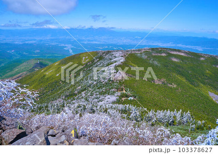春の長野県蓼科山の山頂直下から北東側の尾根と霧氷に覆われた木々を見る 103378627