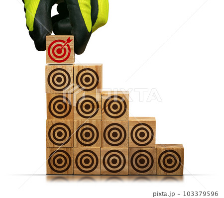 Stack of Wooden Blocks with Many Brown Targets and One Red One 103379596