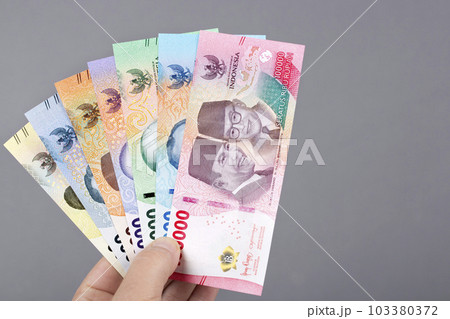 Indonesian money in the hand on a gray background 103380372