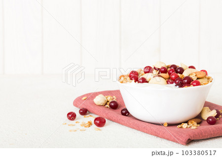 Healthy breakfast food with granola, yogurt, fruits and nuts. Dessert parfait with dried fruits for breakfast 103380517