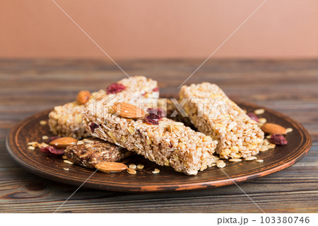 Various granola bars on table background. Cereal granola bars. Superfood breakfast bars with oats, nuts and berries, close up. Superfood concept 103380746