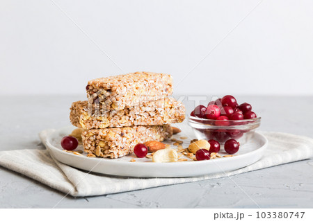 Various granola bars on table background. Cereal granola bars. Superfood breakfast bars with oats, nuts and berries, close up. Superfood concept Various granola bars on table background. Cereal granola bars. Superfood breakfast bars with oats, nuts and berries, close up. Superfood concept 103380747