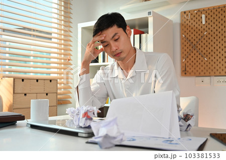 Stressed businessman entrepreneur frustrated with mistakes in annual financial report or business failure 103381533