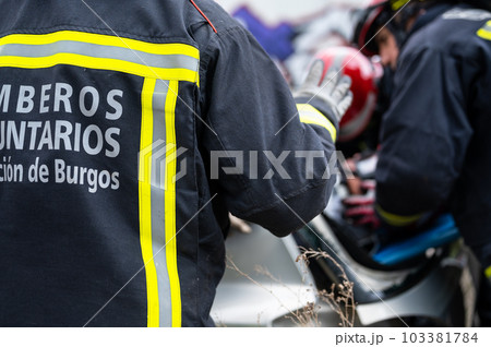 Car Crash Traffic Accident. Firefighters Rescue Injured Trapped Victims. Firemen give First Aid to 103381784