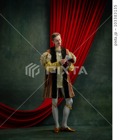 Portrait of young man standing and counting paper money against dark green, vintage background 103383135