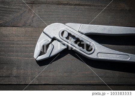 Chrome plumbing wrench on wood texture background Chrome plumbing wrench on wood texture background 103383333