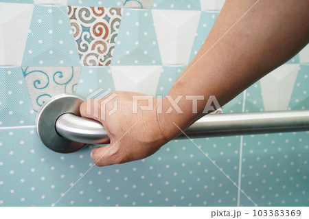 Asian woman patient use toilet support rail in bathroom, handrail safety grab bar, security in nursing hospital. Asian woman patient use toilet support rail in bathroom, handrail safety grab bar, security in nursing hospital. 103383369