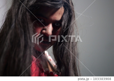 Scary woman in white dress with bloodstain after murder, Halloween concept Scary woman in white dress with bloodstain after murder, Halloween concept 103383908