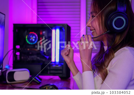 Young woman wearing headphones playing computer game Young woman wearing headphones playing computer game 103384052
