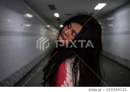 Scary woman in white dress with bloodstain after murder, Halloween concept Scary woman in white dress with bloodstain after murder, Halloween concept 103384132