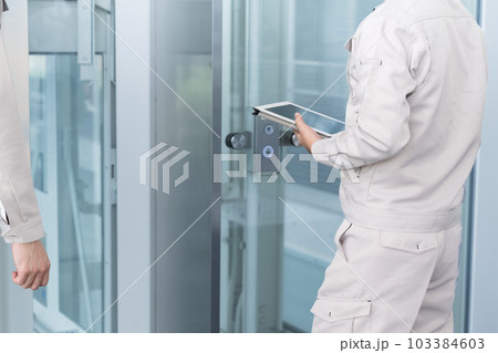 ビルや設備の点検指を差して確認やメンテナンスをする作業員 103384603