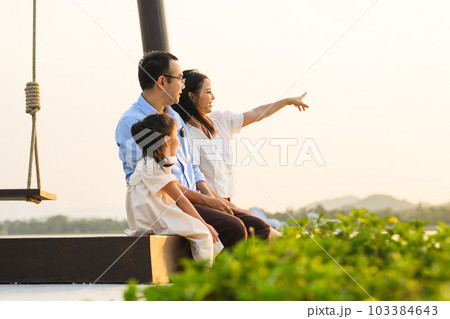 Family enjoying with outdoor activities sitting on swing with sunset 103384643