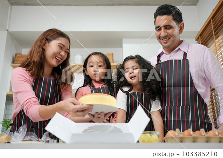 Child making cake with family, Family having fun together in kitchen Child making cake with family, Family having fun together in kitchen 103385210