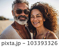 Middle age cuddling couple enjoying time on beach Middle age cuddling couple enjoying time on beach 103393326