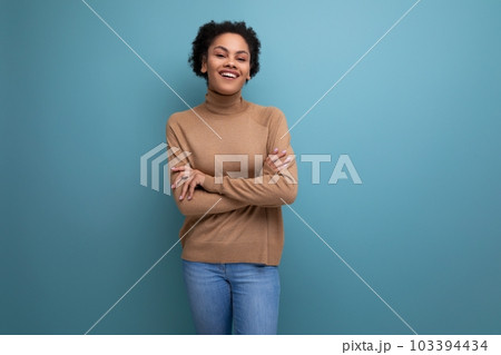 positive young bright latino woman with afro hair gathered in a ponytail against the background with positive young bright latino woman with afro hair gathered in a ponytail against the background with 103394434