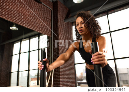 African American woman, crossfit, gym workout, longing and pushing weights, development of strength and endurance. 103394945