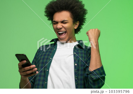 Excited you ng dark-skinned man with a smartphone Excited you ng dark-skinned man with a smartphone 103395796
