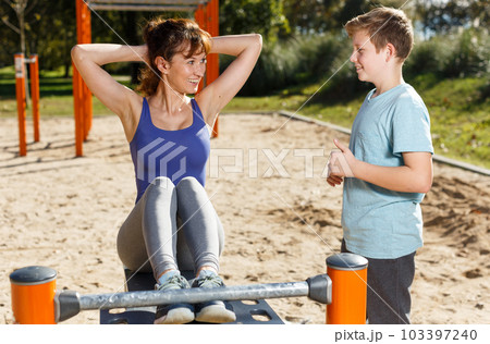 Woman with boy doing push-ups Woman with boy doing push-ups 103397240