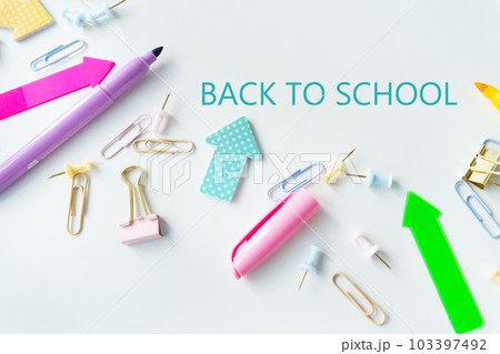 Top view of bright colored school supplies with blank paper and back to school lettering. Top view of bright colored school supplies with blank paper and back to school lettering. 103397492