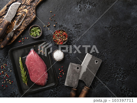 Raw beef fillet steak in vacuum tray with rosemary on on black background  103397711