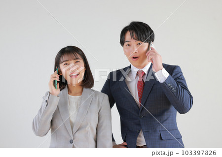 電話での吉報に喜ぶビジネスウーマンとビジネスマン_2 電話での吉報に喜ぶビジネスウーマンとビジネスマン_2 103397826