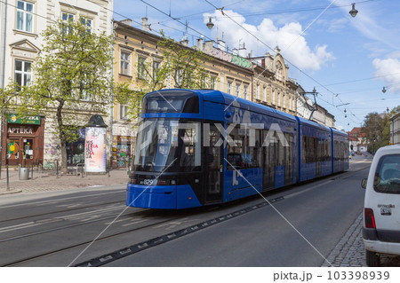 【ポーランド】クラクフ旧市街の歴史的街並みを走り抜ける近代的な青い路面電車 【ポーランド】クラクフ旧市街の歴史的街並みを走り抜ける近代的な青い路面電車 103398939