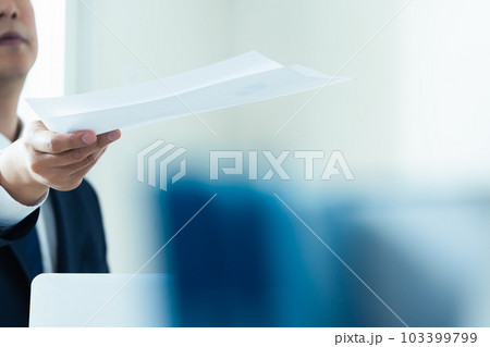 書類を渡すビジネスマン 103399799