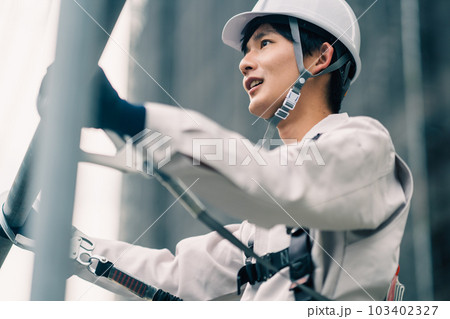 ビル建設の高所で働く若い職人 103402327
