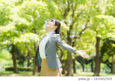 新緑の中で深呼吸をする女性の写真 新緑の中で深呼吸をする女性の写真 103402505