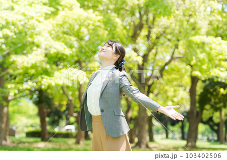 新緑の中で深呼吸をする女性の写真 新緑の中で深呼吸をする女性の写真 103402506