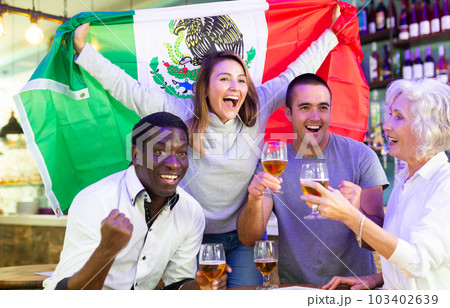 Happy fans celebrating the victory of Mexican team in bar 103402639